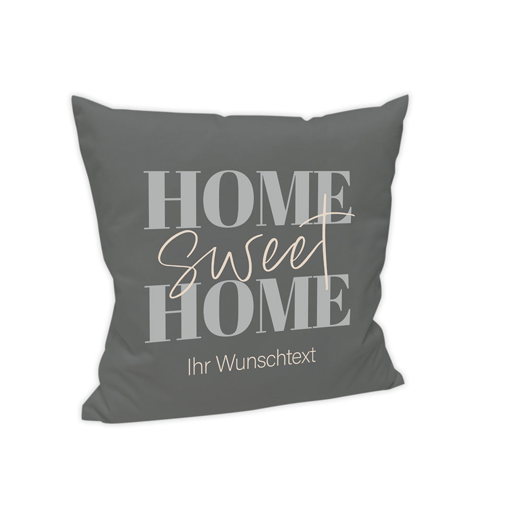 Der Hintergrund des Kissens ist Dunkelgrau dargestellt. Mittig steht in verschiedenen Schriftarten "Home Sweet Home" und darunter wird der Text "Ihr Wunschtext" angezeigt.