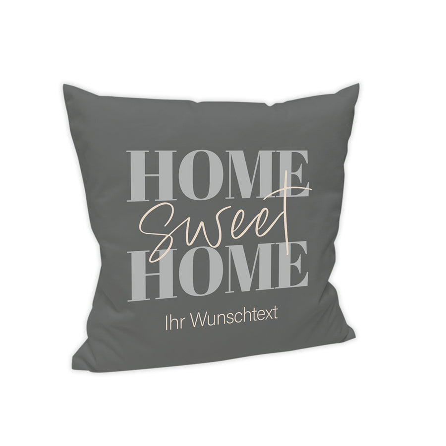 Der Hintergrund des Kissens ist Dunkelgrau dargestellt. Mittig steht in verschiedenen Schriftarten "Home Sweet Home" und darunter wird der Text "Ihr Wunschtext" angezeigt.