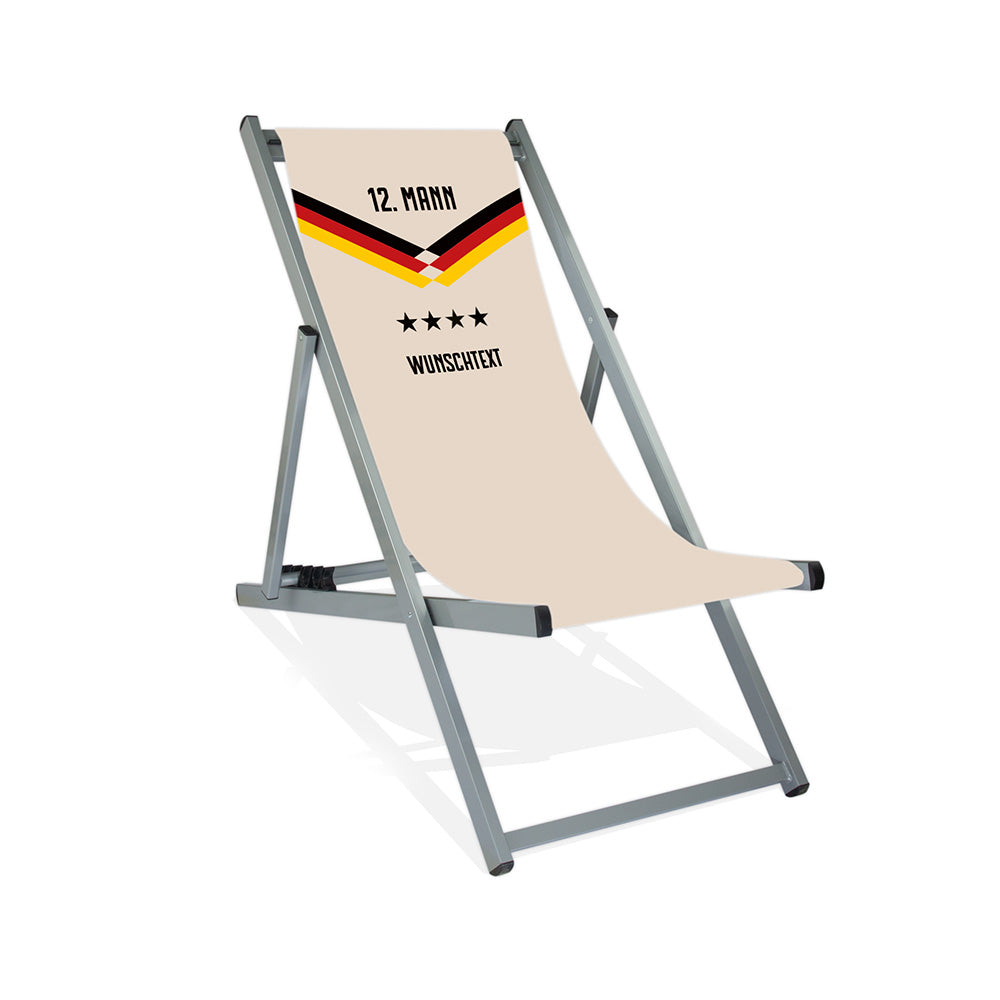 Mittig ist ein silberner Aluminium-Liegestuhl ohne Armlehne abgebildet.
Naturfarbener Hintergrund im Nationalelf Trikot Stil.