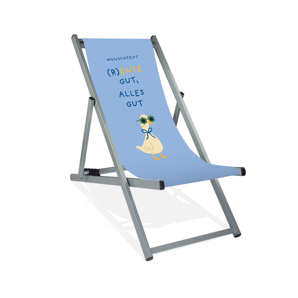 Mockup eines personalisierten Aluminiumliegestuhls ohne Armlehne mit himmelblauen Hintergrund, Enten-Motiv mit Sonnenbrille und Schriftzug "(R)Ente gut, alles gut."
Die Farbe des Liegestuhls ist Silber.
