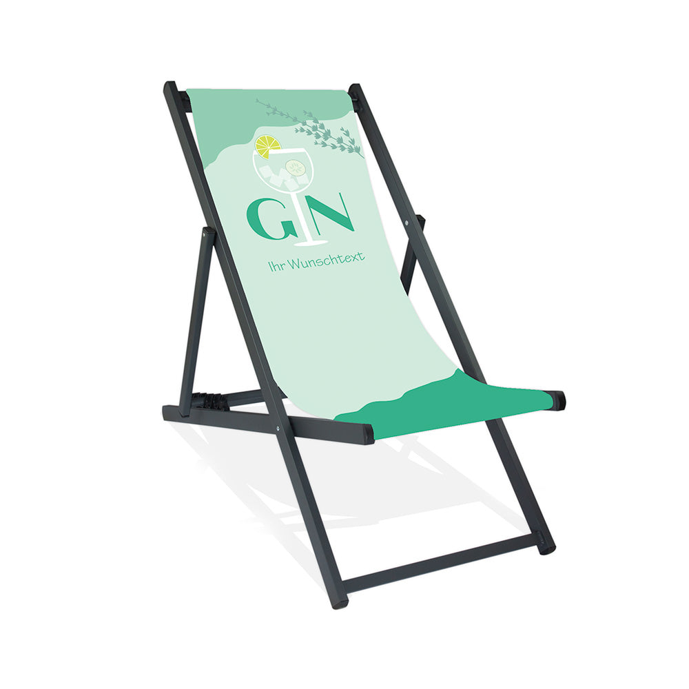 Mittig Aluminium-Liegestuhl ohne Armlehne in schwarzer Lasur. Das Motiv auf der Stoffbahn ist Pastellmint. Im oberen Bereich steht "Gin", wobei das "i" ein Cocktailglas darstellt. Unter dem Wort "Gin" steht "Ihr Wunschtext".
Über dem gesamten Schriftzug ist rechts noch ein Kräuterzweig in Grün dargestellt.