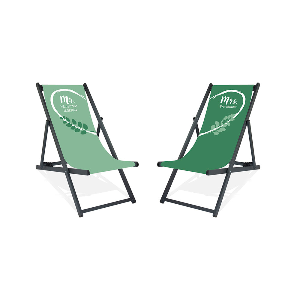 Es sind zwei Aluminium-Liegestühle ohne Armlehne in der Lasur Schwarz abgebildet.
Linker Stuhl mit Hintergrund in Mint, linke weiße Herzhälfte und grüne Blätter.
Rechter Stuhl mit Hintergrund dunkleres Grün und rechte weiße Herzhälfte.
Text linker Stuhl: Mr. 
Text rechter Stuhl: Mrs.