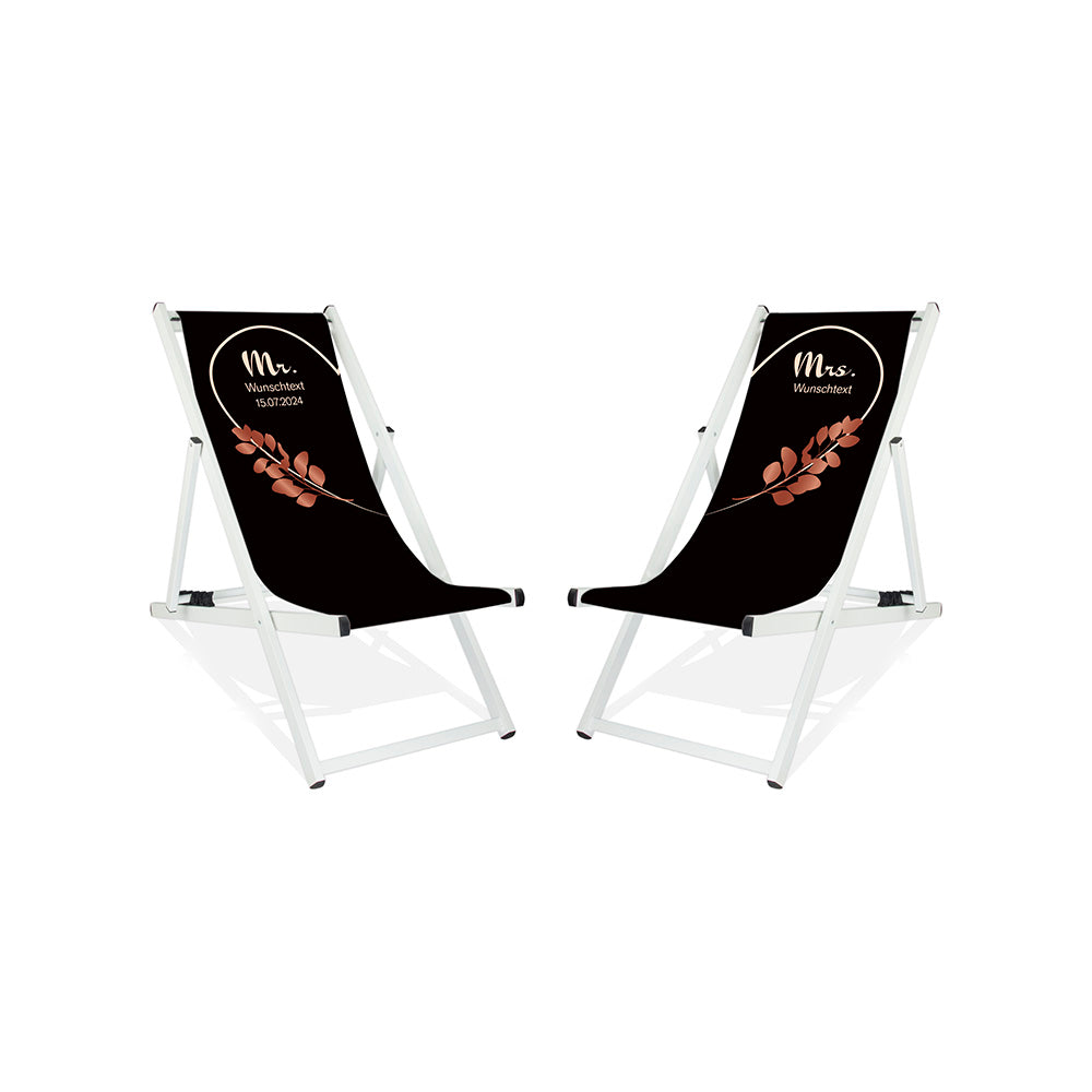 Es sind zwei Aluminium-Liegestühle ohne Armlehne in der Lasur Weiß abgebildet.
Hintergrund beider Liegestühle in Schwarz. Linker Stuhl: Linke Herzhälfte in Creme und Rosé Blätter.
Rechter Stuhl rechte Herzhälfte in Creme und Rosé Blätter.
Text linker Stuhl: Mr. 
Text rechter Stuhl: Mrs.