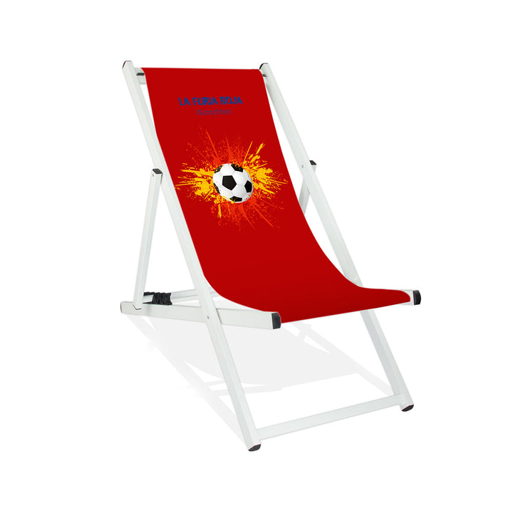 Aluminiumliegestuhl in Weiß im Spanien Design zur WM 2026 mit Fußball auf rot-gelb-roten Farbklecks und personalisierbaren Text oberhalb. Über dem Wunschtext steht in blau "La Furia Roja".
Der Hintergrund ist rot.