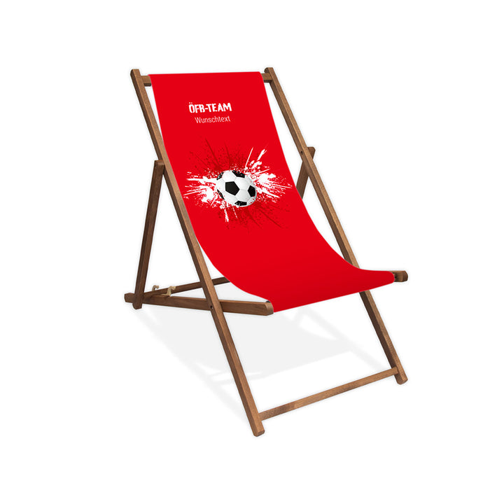 Liegestuhl ohne Armlehne dunkelbraun im Österreich Design zur WM 2026 mit Fußball auf rot-weiß-roten Farbklecks und personalisierbaren Text oberhalb. Über dem Wunschtext steht in weiß "ÖFB-Team".
Der Hintergrund ist rot.