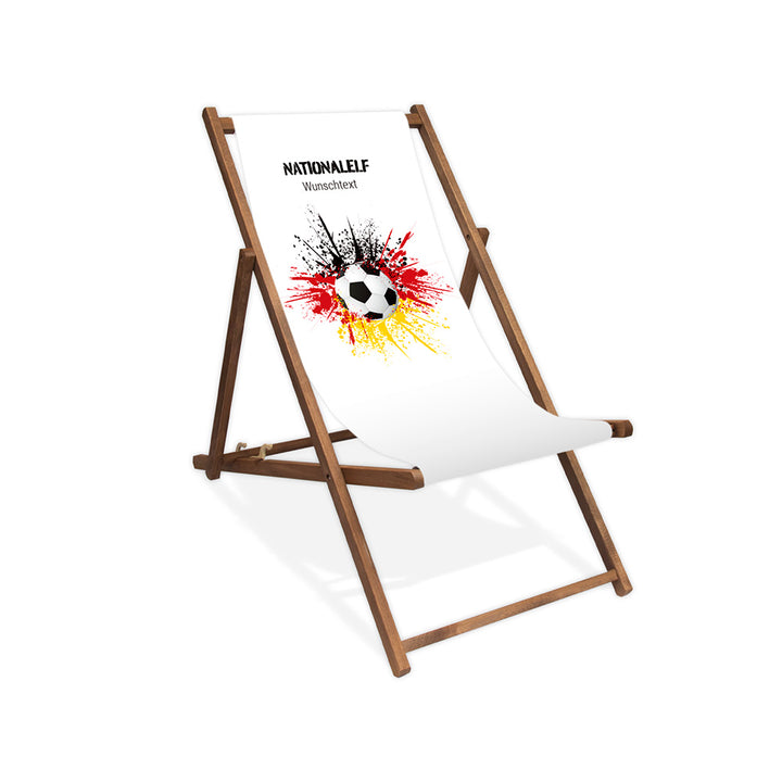 Liegestuhl ohne Armlehne dunkelbraun im Deutschland Design zur WM 2026 mit Fußball auf schwarz-rot-goldenem Farbklecks und personalisierbaren Text oberhalb. Über dem Wunschtext steht "Nationalelf".