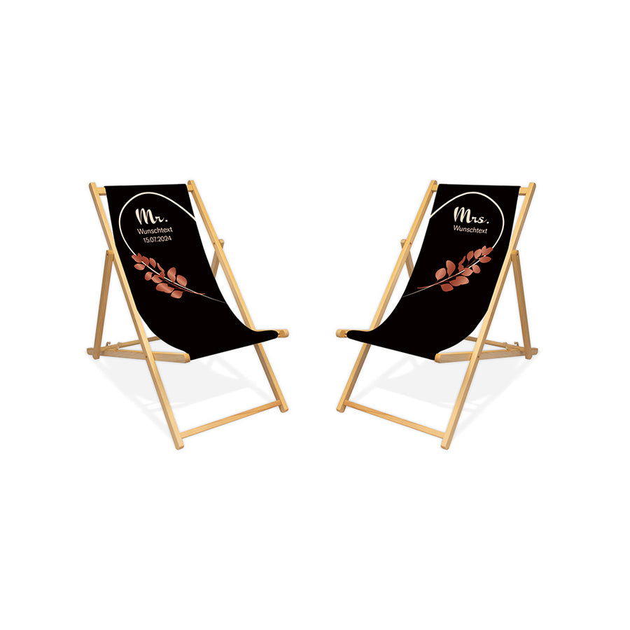 Es sind zwei Holzliegestühle ohne Armlehne in der Lasur farblos abgebildet.
Hintergrund beider Liegestühle in Schwarz. Linker Stuhl: Linke Herzhälfte in Creme und Rosé Blätter.
Rechter Stuhl rechte Herzhälfte in Creme und Rosé Blätter.
Text linker Stuhl: Mr. 
Text rechter Stuhl: Mrs.