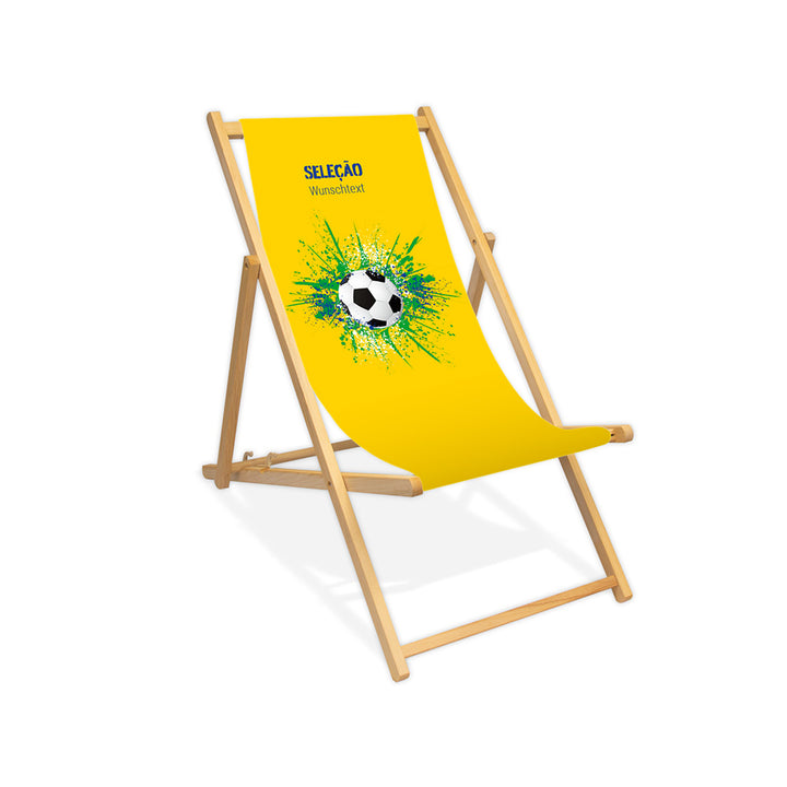 Liegestuhl ohne Armlehne farblos im Brasilien Design zur WM 2026 mit Fußball auf grün-blau-weißen Farbklecks und personalisierbaren Text oberhalb. Über dem Wunschtext steht in blau "Selecao".
Der Hintergrund ist gelb.
