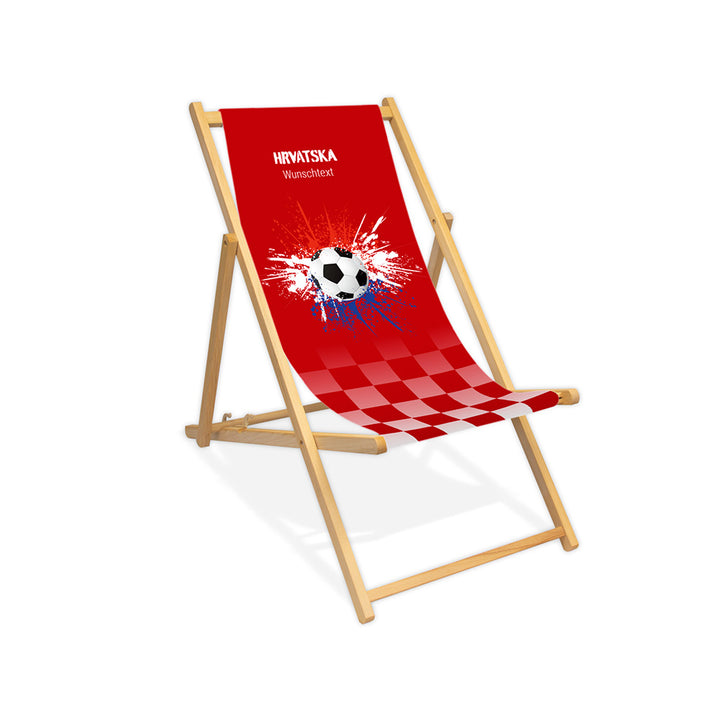 Liegestuhl ohne Armlehne farblos im Kroatien Design zur WM 2026 mit Fußball auf rot-weiß-blauen Farbklecks und personalisierbaren Text oberhalb. Über dem Wunschtext steht "Hrvatska".
Der Hintergrund ist rot. Im unteren ein Verlauf zu rot-weiß kariert.