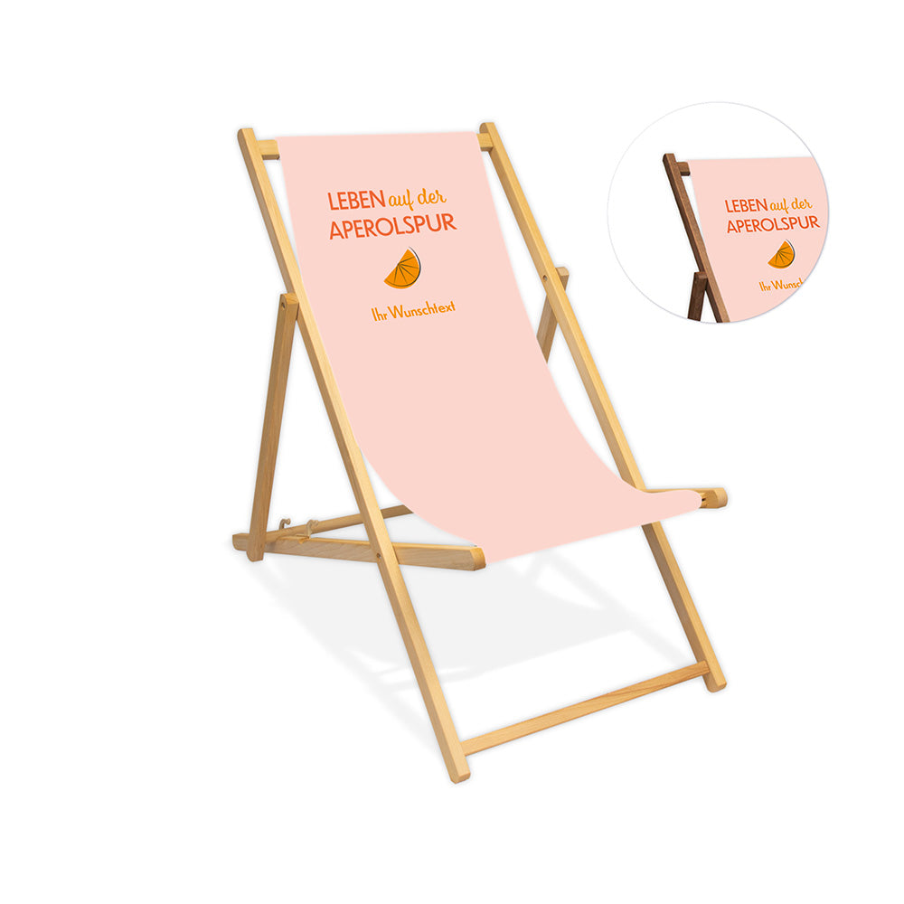 Mittig ist ein farbloser Holzliegestuhl ohne Armlehne abgebildet.
Helles Motiv mit dem Spruch "Leben auf der Aperolspur". 
Neben dem Liegestuhl ist in einem Kreis die Lasurfarbe dunkelbraun abgebildet.
