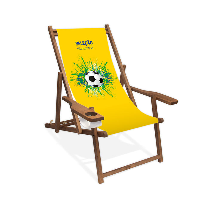 Liegestuhl mit Armlehne dunkelbraun im Brasilien Design zur WM 2026 mit Fußball auf grün-blau-weißen Farbklecks und personalisierbaren Text oberhalb. Über dem Wunschtext steht in blau "Selecao".
Der Hintergrund ist gelb.