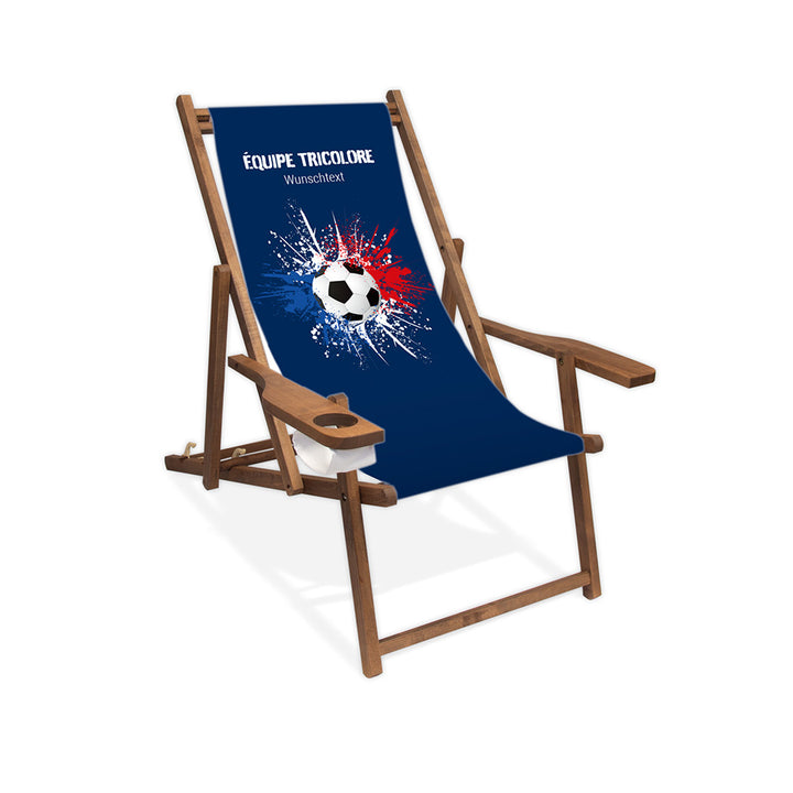 Liegestuhl mit Armlehne dunkelbraun im Frankreich Design zur WM 2026 mit Fußball auf blau-weiß-roten Farbklecks und personalisierbaren Text oberhalb. Über dem Wunschtext steht in weiß "Equipe Tricolore".
Der Hintergrund ist blau.