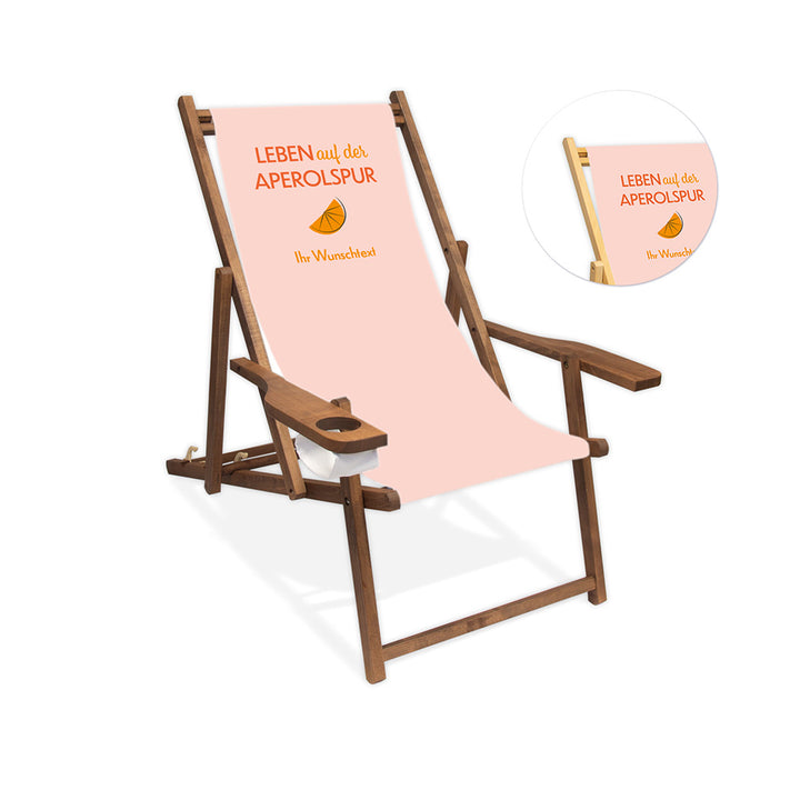 Mittig ist ein dunkelbrauner Holzliegestuhl mit Armlehne abgebildet.
Helles Motiv mit dem Spruch "Leben auf der Aperolspur". 
Neben dem Liegestuhl ist in einem Kreis die Lasurfarbe farblos abgebildet.