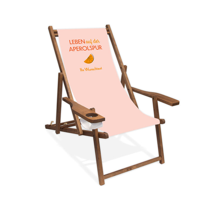 Mittig ist ein dunkelbrauner Holzliegestuhl mit Armlehne abgebildet.
Helles Motiv mit dem Spruch "Leben auf der Aperolspur". 