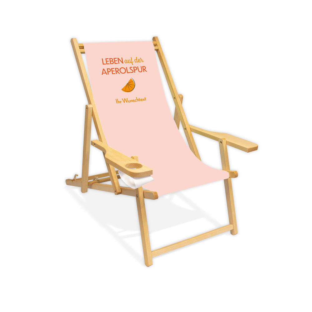 Mittig ist ein farbloser Holzliegestuhl mit Armlehne abgebildet.
Helles Motiv mit dem Spruch "Leben auf der Aperolspur". 