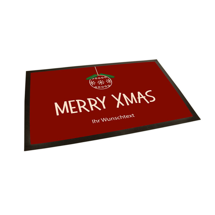 Der Hintergrund der Fußmatte ist in einem Dunkelrot gehalten. Im oberen ist eine abstrahierte 2D Weihnachtskugel zu erkennen.
Darunter steht groß geschrieben "Merry  Xmas" und darunter "Ihr Wunschtext.