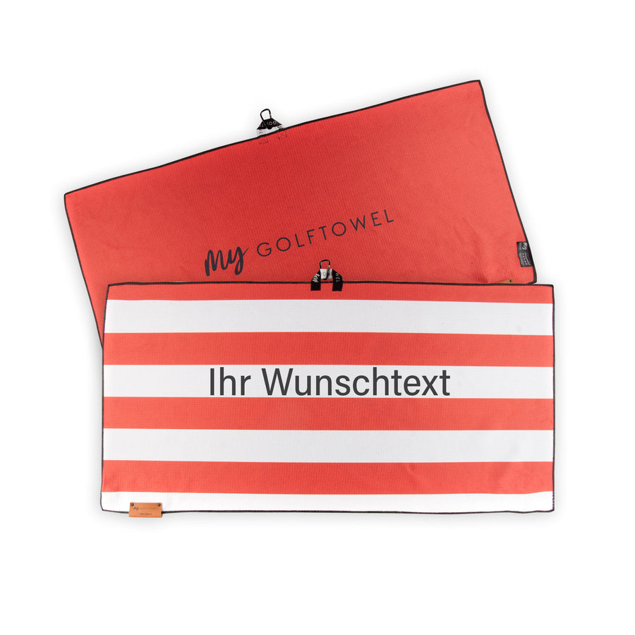 Golftowel Large mit einem horizontal gestreiften Muster Rot-Weiß. Auf dem Golftowel steht Mittig in einer schwarzen, serifenlosen Schrift geschrieben "Ihr Wunschtext". Die Rückseite des Golftowels ist in Rot, dargestellt. Hier steht mittig der schwarze Schriftzug "MyGolftowel". Im unteren Bereich befindet sich ein braunes Lederpatch und oben ist eine Schlaufe und Karabiner angebracht.