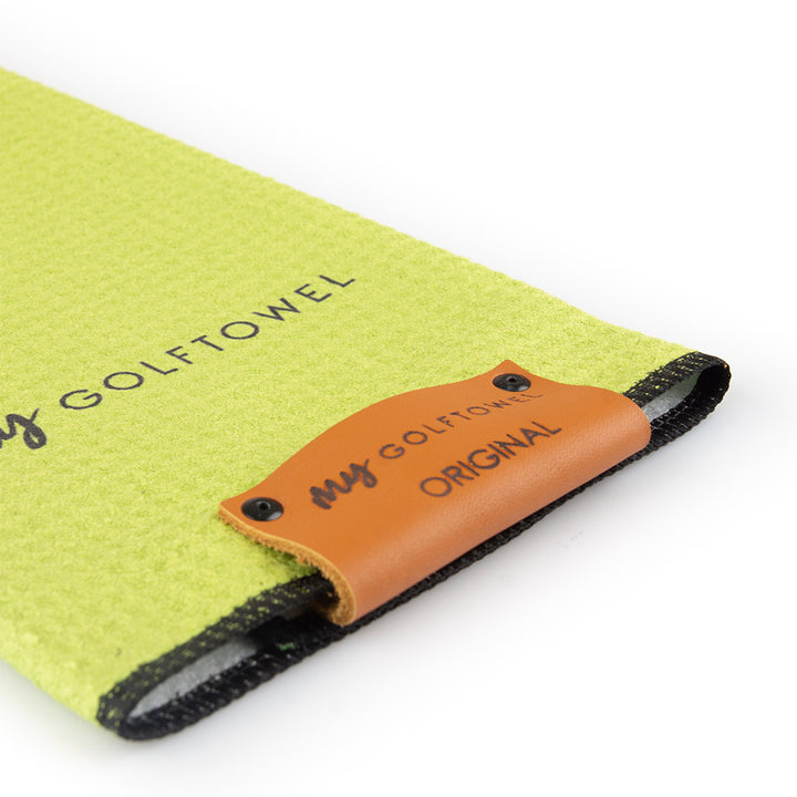 Detailfoto vom Lederpatch in braun mit gebrandeten "MyGolftowel Original" Schriftzug auf einem lemon Golftowel Small.