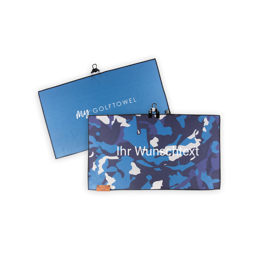 Golftowel Medium in blauen Camouflage Muster. Auf dem Golftowel steht Mittig in einer weißen, serifenlosen Schrift geschrieben "Ihr Wunschtext". Die Rückseite des Golftowels ist Blau dargestellt. Hier steht mittig der Schriftzug "MyGolftowel". Im unteren Bereich befindet sich ein braunes Lederpatch und oben ist eine Schlaufe und Karabiner angebracht.