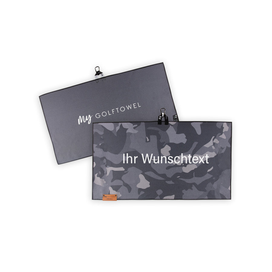 Golftowel Medium in grauem Camouflage Muster. Auf dem Golftowel steht Mittig in einer weißen, serifenlosen Schrift geschrieben "Ihr Wunschtext". Die Rückseite des Golftowels ist Grau dargestellt. Hier steht mittig der Schriftzug "MyGolftowel". Im unteren Bereich befindet sich ein braunes Lederpatch und oben ist eine Schlaufe und Karabiner angebracht.