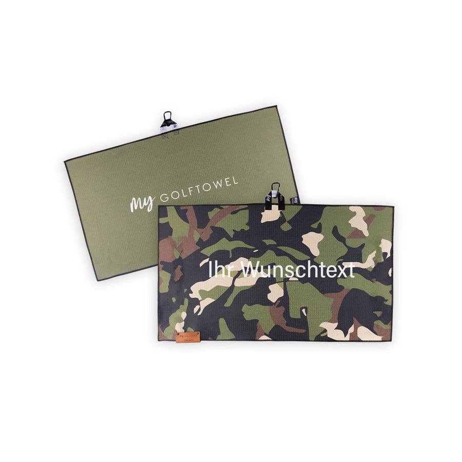 Golftowel Medium in grünem Camouflage Muster. Auf dem Golftowel steht Mittig in einer weißen, serifenlosen Schrift geschrieben "Ihr Wunschtext". Die Rückseite des Golftowels ist Khaki-Grün dargestellt. Hier steht mittig der Schriftzug "MyGolftowel". Im unteren Bereich befindet sich ein braunes Lederpatch und oben ist eine Schlaufe und Karabiner angebracht.