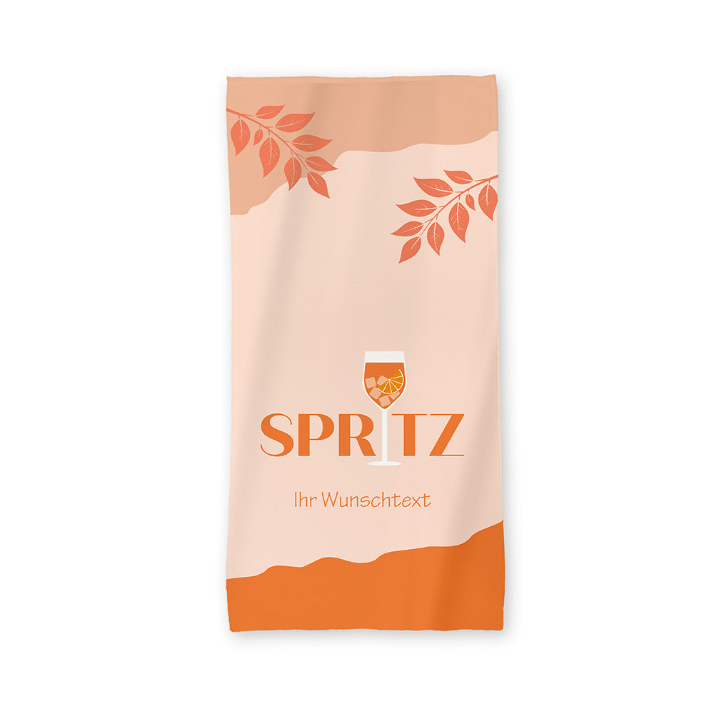Der Hintergrund des Handtuchs ist in einem Pastell-Orange dargestellt.
Im unteren Bereich ist das Orange dunkler dargestellt. Im oberen Bereich ist das Orange in einem mittleren Ton abgesetzt. Dort befinden sich auch in Kräuterzweige in Orange.
Im unteren Drittel steht das Wort "Spritz", wobei das "i" durch ein Cocktailglas ersetzt wurde.
Under "Spritz" steht noch "Ihr Wunschtext".