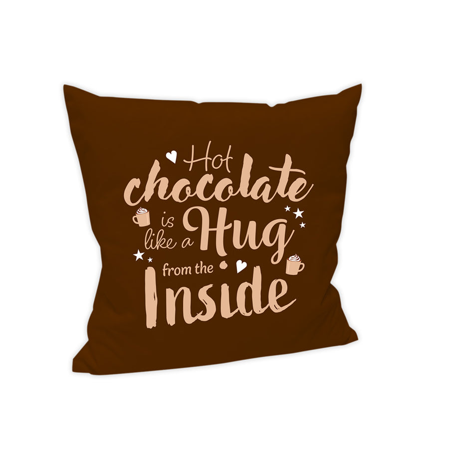 Der Hintergrund dieses Kissens ist in einem warmen dunkelbraun gehalten. Auf mehereren Zeilten steht in cremefarbener Schrift "Hot chocolate is like a hug from the inside". Um die Schrift ringsum sind Sterne, Herzen sowie Tassen mit einer Sahnehaube verteilt.